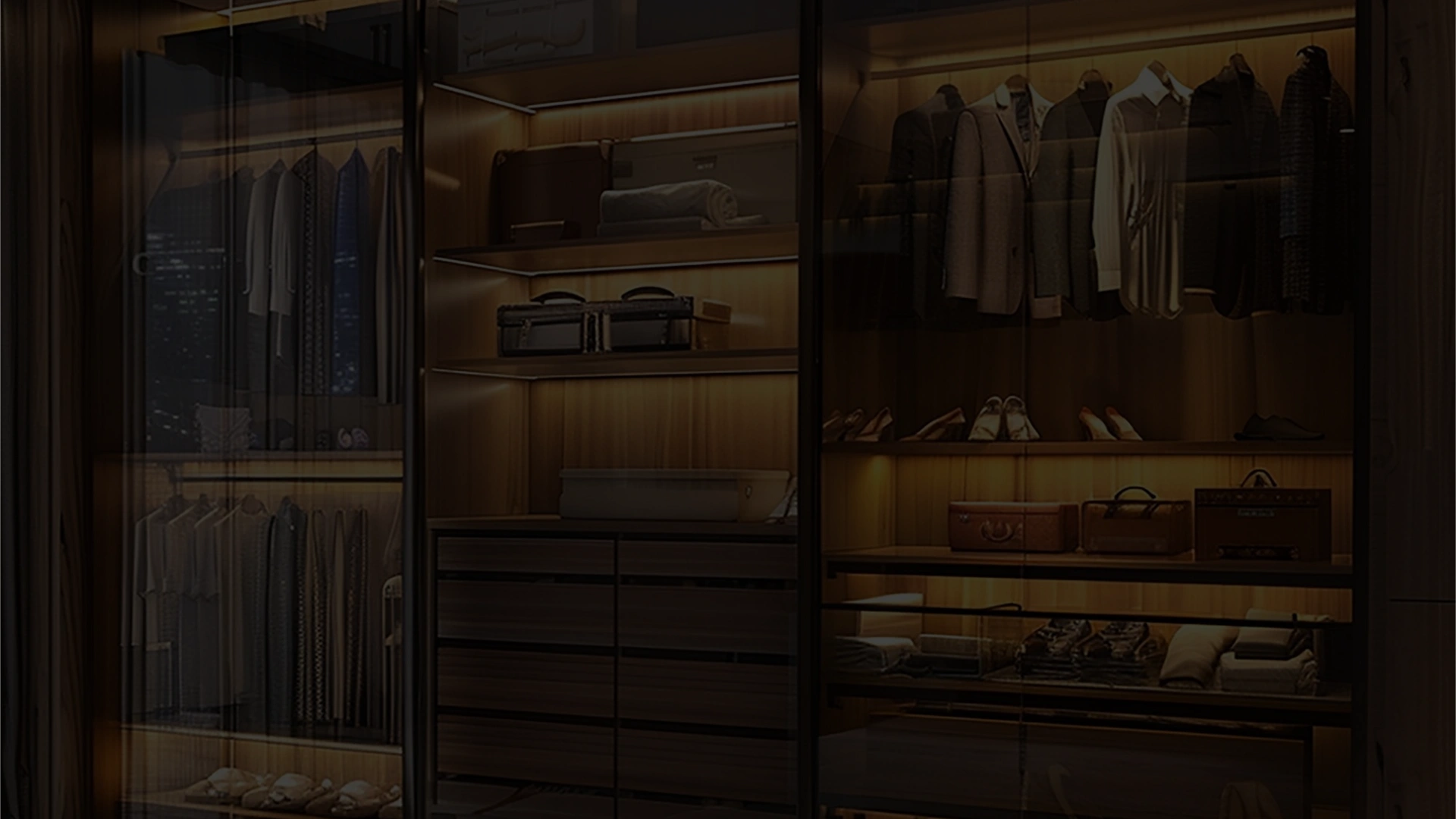Modern custom closet system with glass doors, organized storage, and warm LED lighting