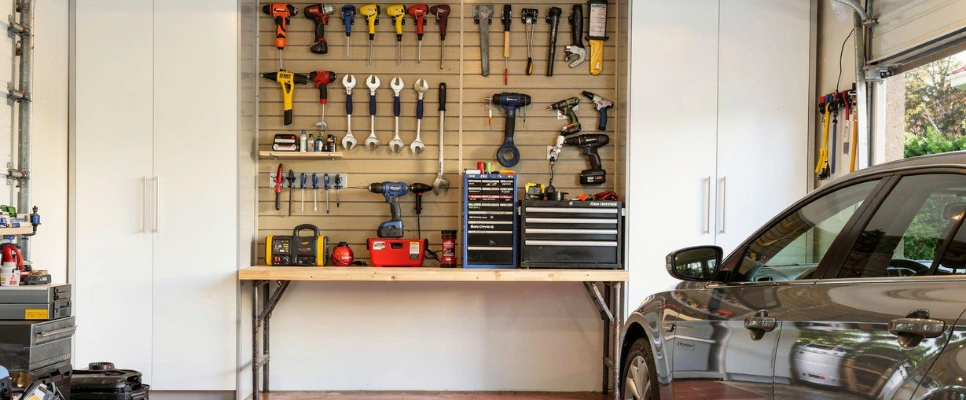 Custom garage cabinets with wall-mounted tool storage and organized workspace